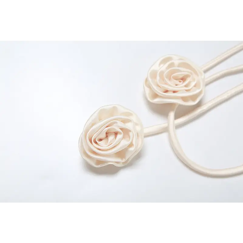 Cream-colored rose curtain tiebacks.