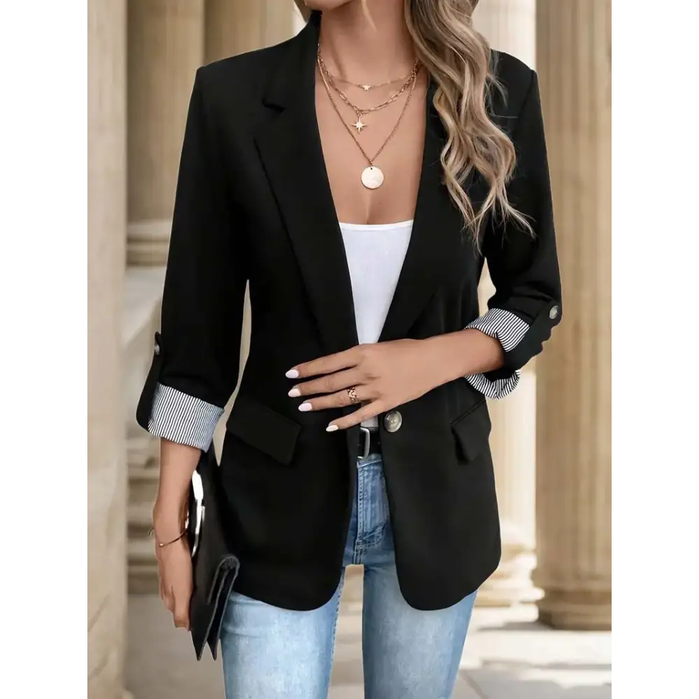 Black blazer with rolled-up striped sleeves.