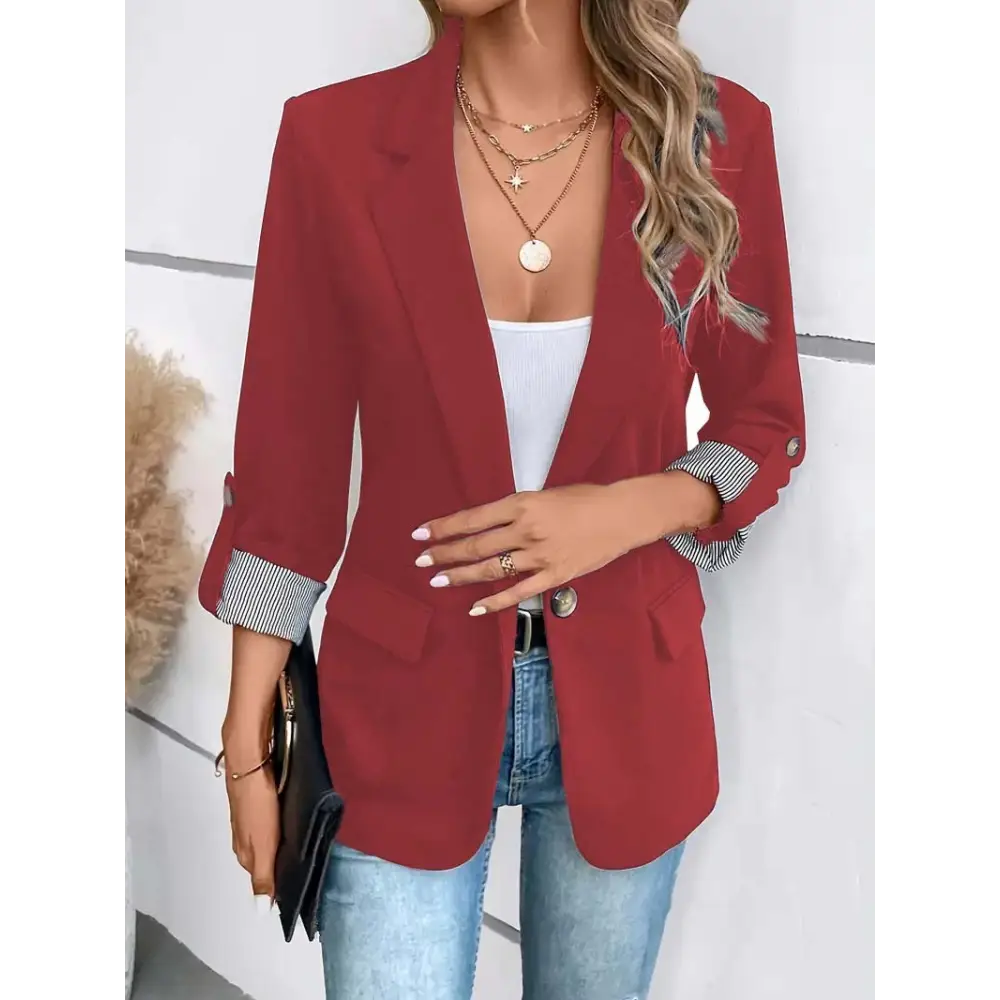Burgundy blazer with striped cuffs.