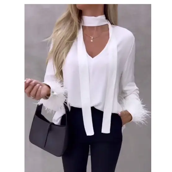 White blouse with feather cuffs.