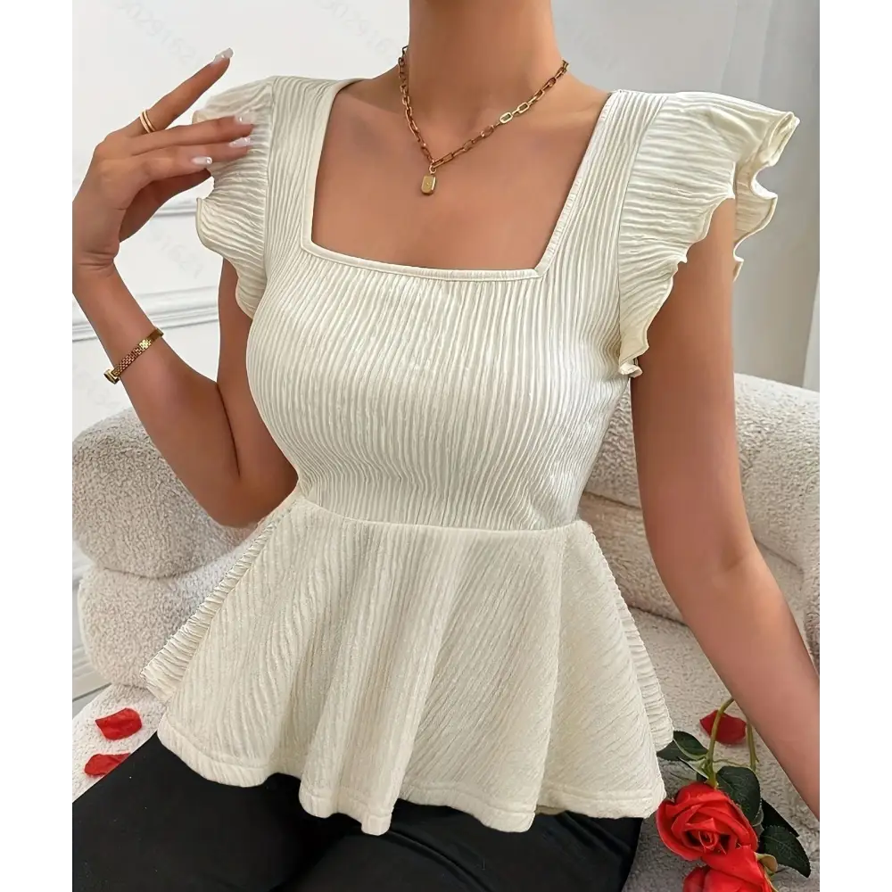 Ivory peplum top with square neckline.