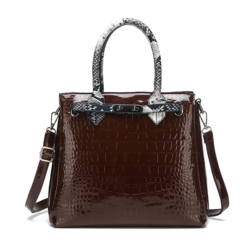 Brown crocodile-patterned handbag with snake-print handles.