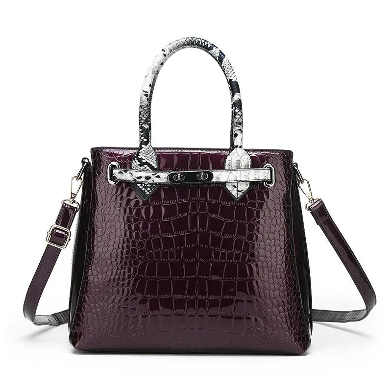 Burgundy crocodile-patterned handbag with snake-print handles.