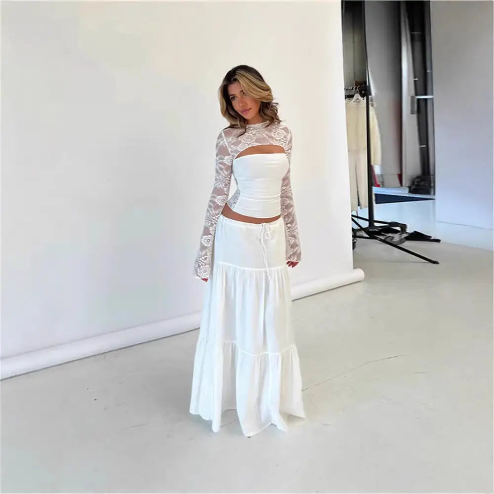 Woman in white lace-sleeved top and tiered skirt.