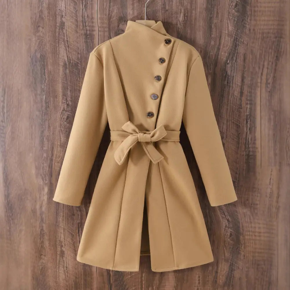 Tan belted coat with asymmetrical button closure.