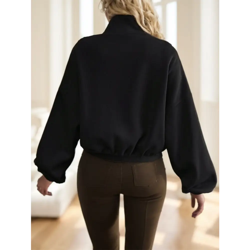 Black bomber jacket with brown pants.