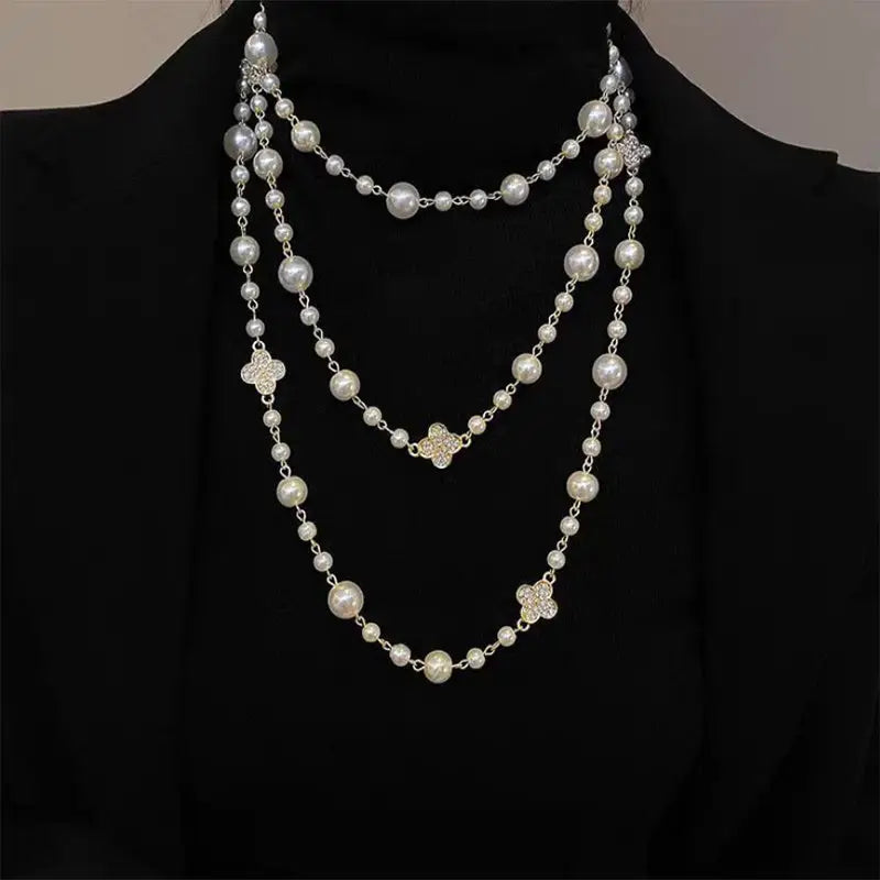 Three-strand pearl and clover necklace.