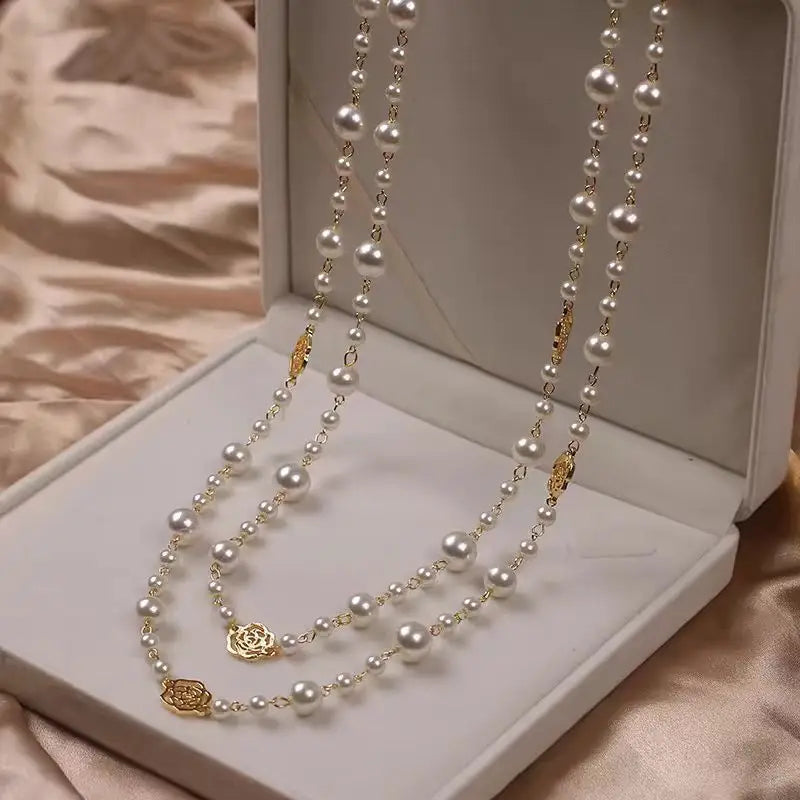 Pearl and gold-toned rose necklaces.