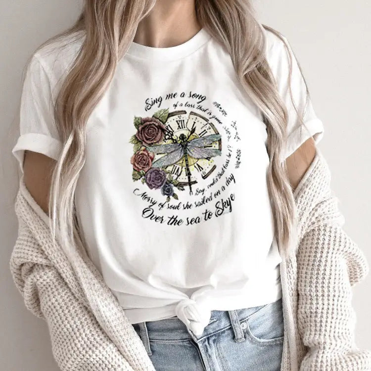 White t-shirt with a clock, dragonfly, and floral design.