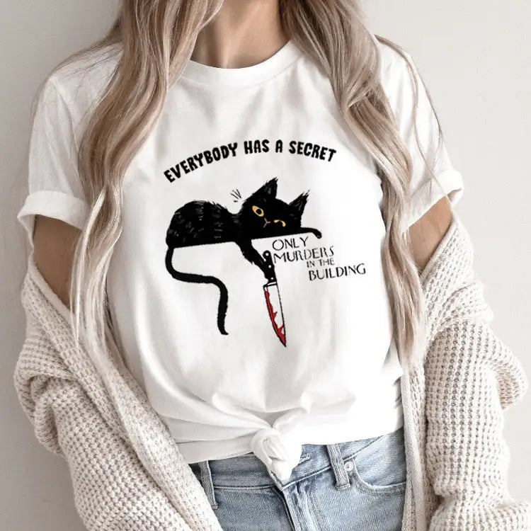 White t-shirt with cat and knife graphic.