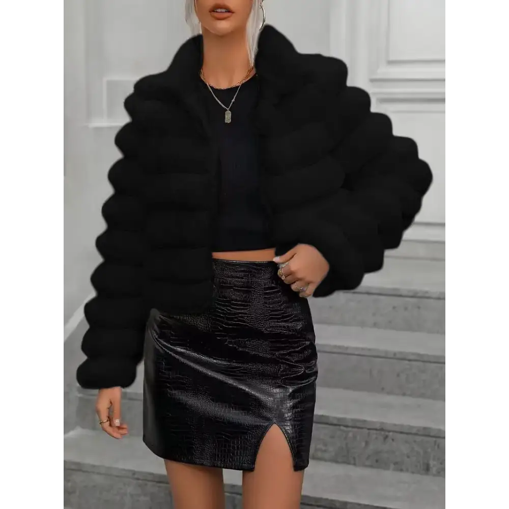 Woman in black faux fur jacket and faux leather skirt.