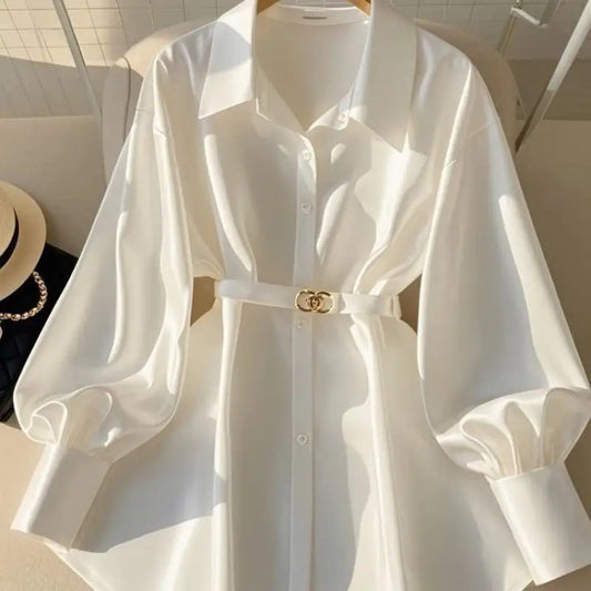 White, belted, long-sleeved blouse.