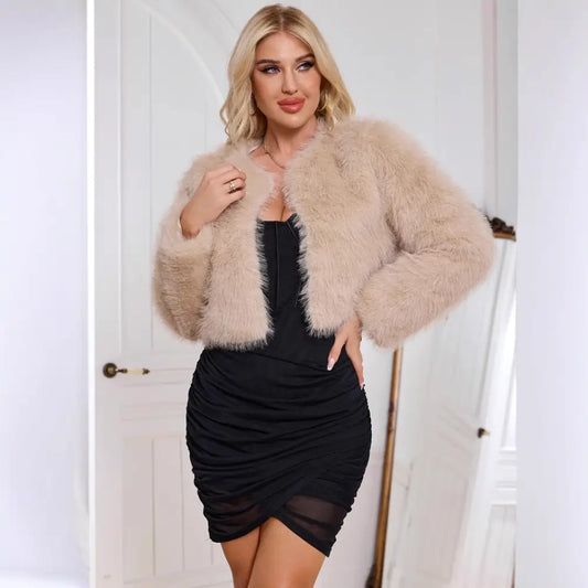 Woman wearing a fuzzy beige jacket and black dress.
