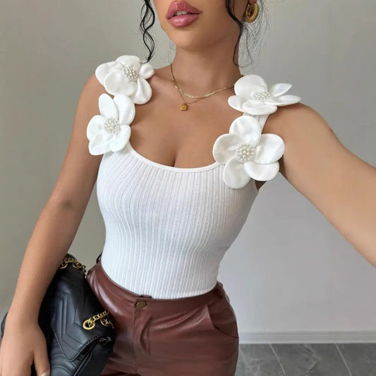 White ribbed tank top with floral shoulder embellishments.