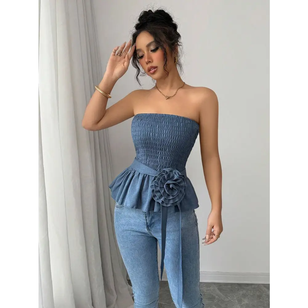 Woman in a blue strapless top and jeans.