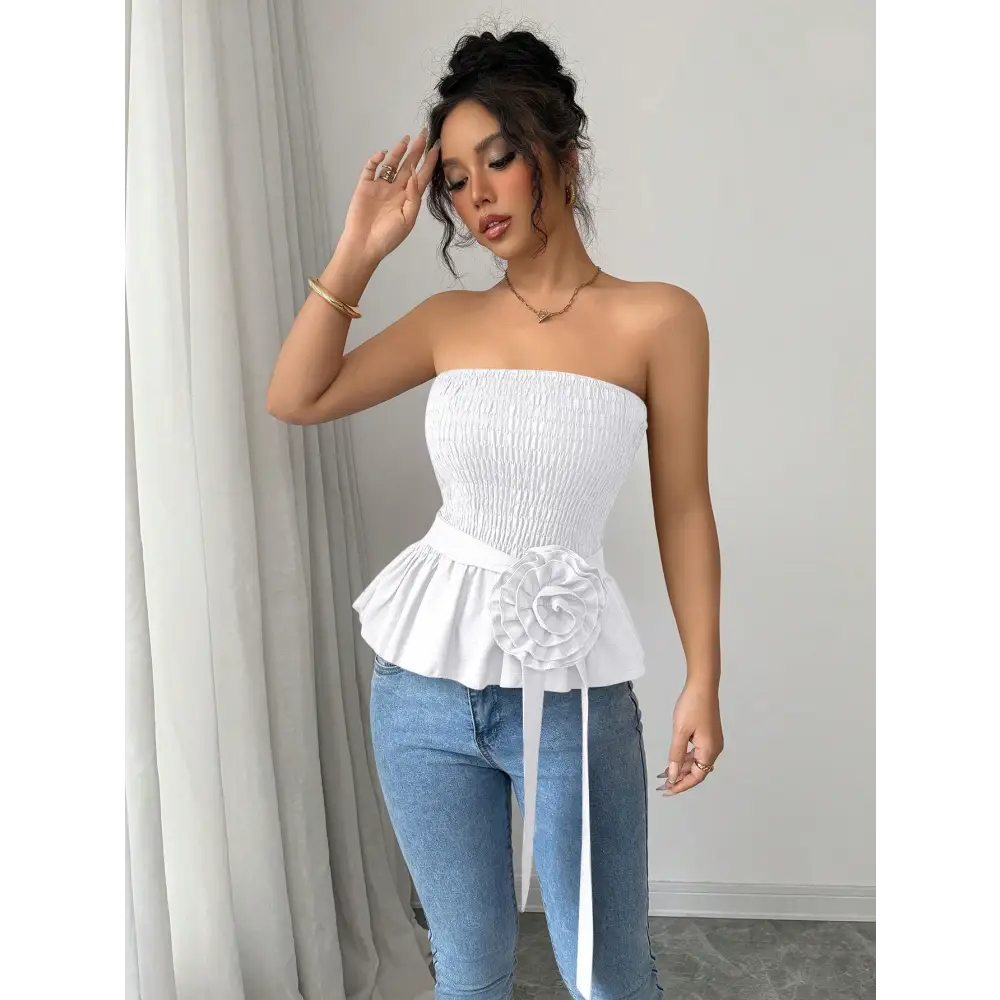Woman in white strapless top and jeans.