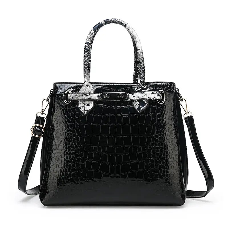 Black crocodile-patterned handbag with snake-print handles.