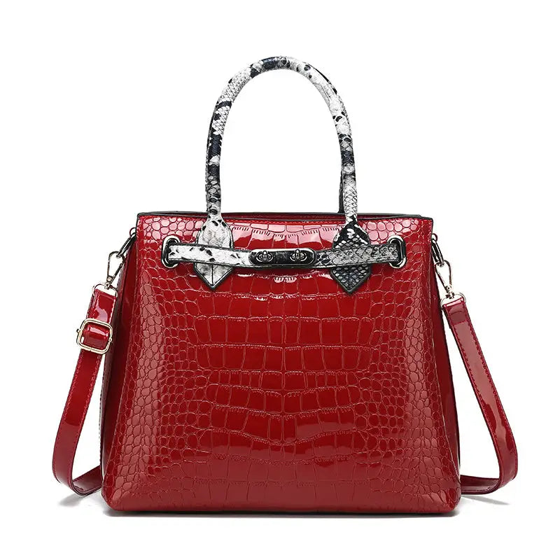 Red crocodile-patterned handbag with snake-print handles.