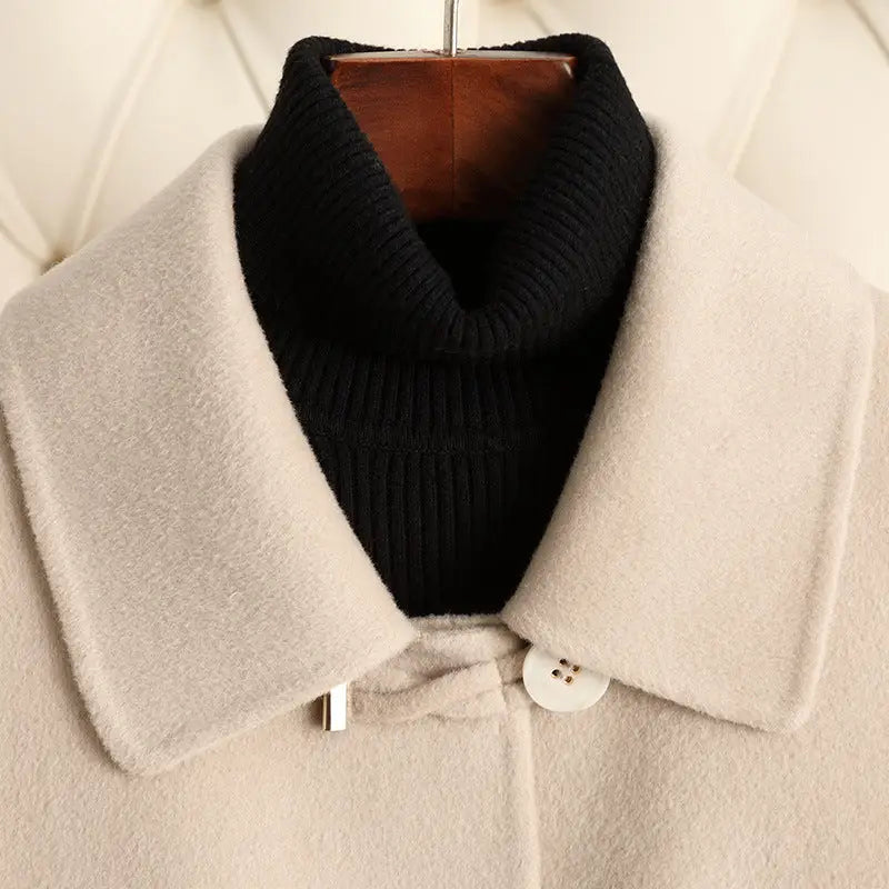 Beige coat with a black turtleneck.
