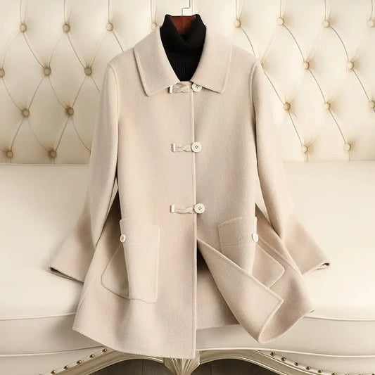 Beige wool coat with toggle closures.