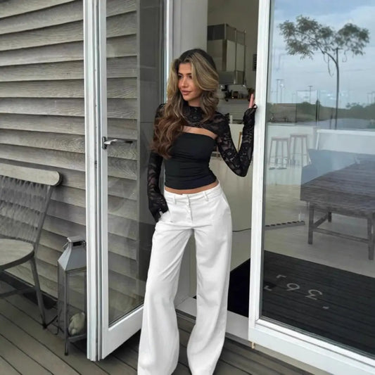 Woman in black top and white pants.