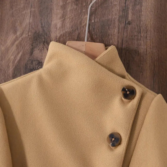 Beige coat with asymmetrical button closure.