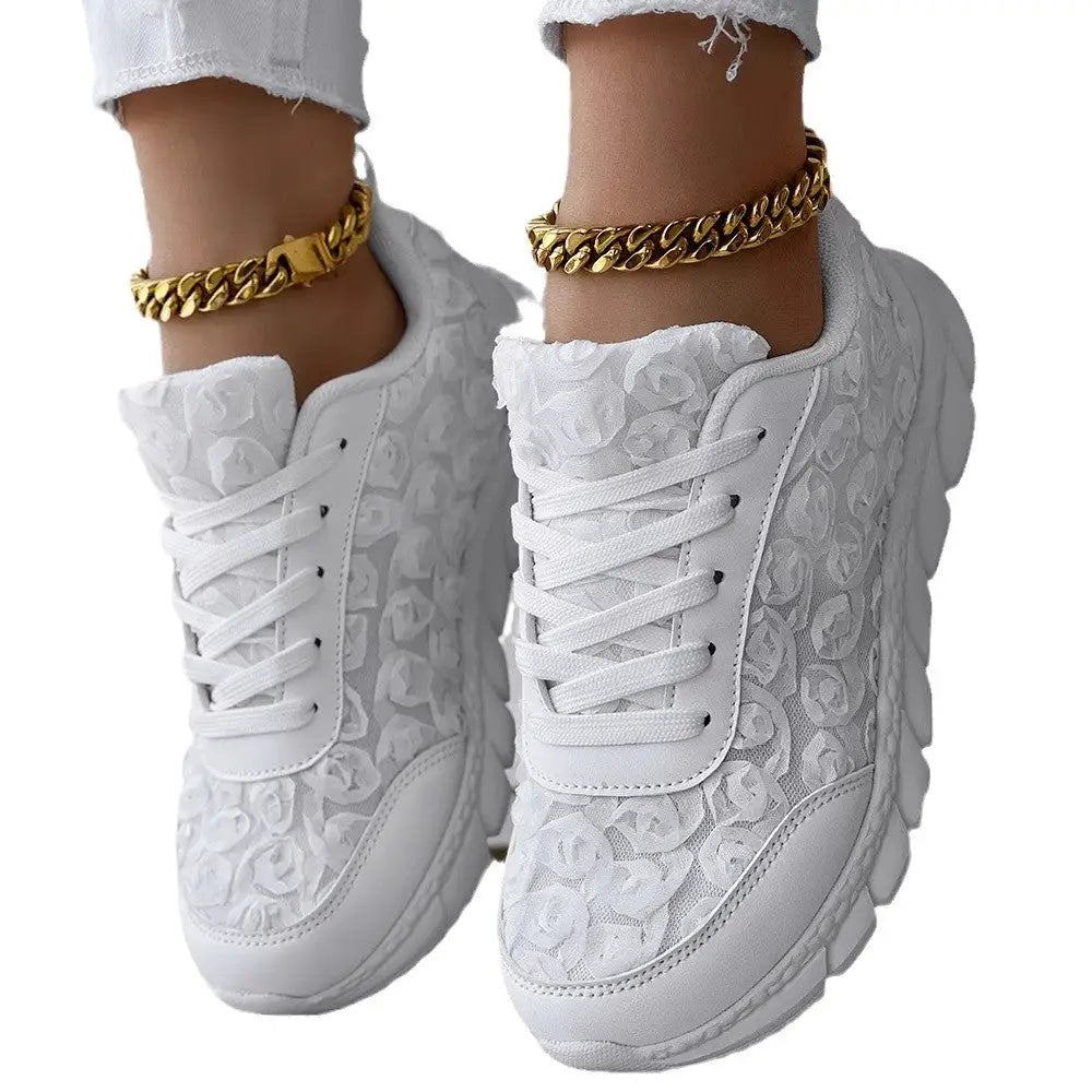 White floral-patterned sneakers with gold ankle bracelets.