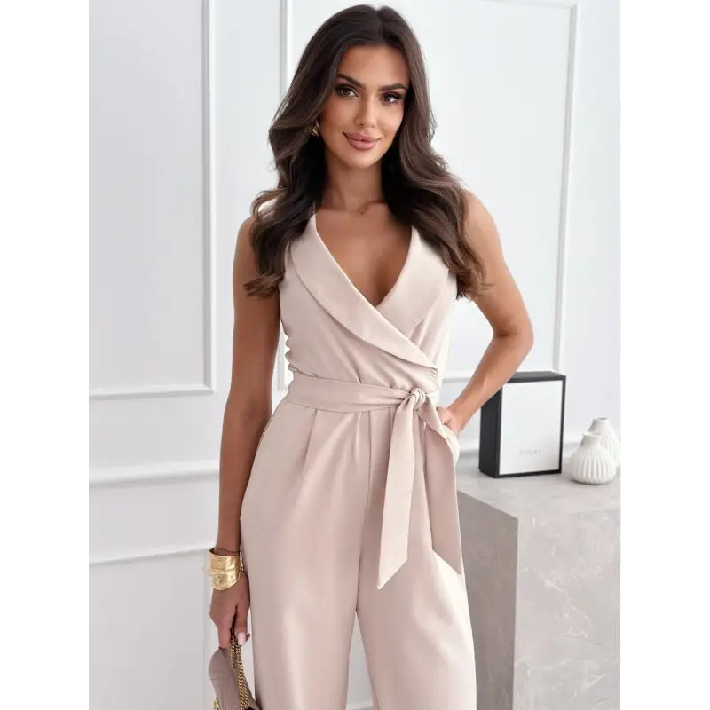 Beige sleeveless jumpsuit with tie waist.