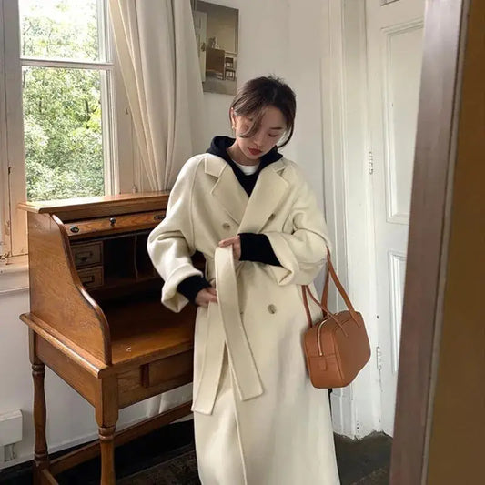 Woman’s belted white trench coat.
