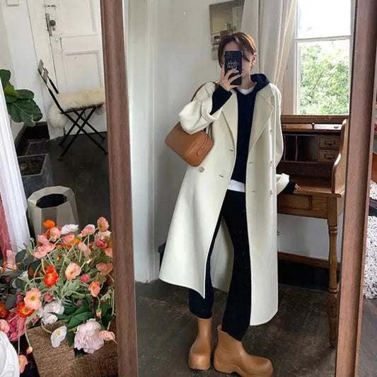 Woman’s long, cream-colored coat.