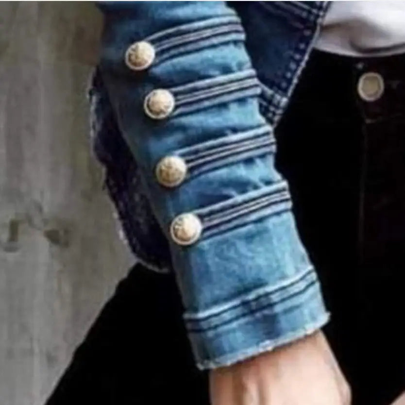 Denim jacket sleeve with decorative gold buttons.