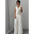 Woman in a white vest and pleated pants.